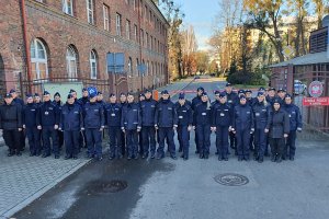 Grupowe zdjęcie słuchaczy przed bramą Szkoły Policji.