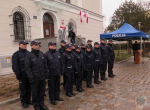 Policjanci stoją przed budynkiem, w tle widać namiotem z napisem &quot;Policja&quot; podczas uroczystości otwarcia Komendy Powiatowej Policji w Brzegu