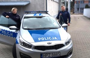 policjant i policjantka przy radiowozie