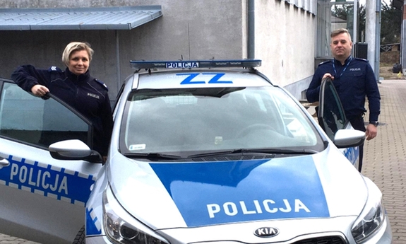 policjant i policjantka przy radiowozie