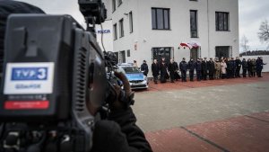 uczestnicy uroczystości stoją przed nowym budynkiem komisariatu Policji