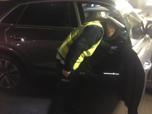 policjant ruchu drogowego sprawdza wnętrze zabezpieczonego samochodu marki audi