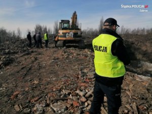 zdjęcie kolorowe:  policjanci podczas zabezpieczenia miejsce nielegalnego składowania odpadów