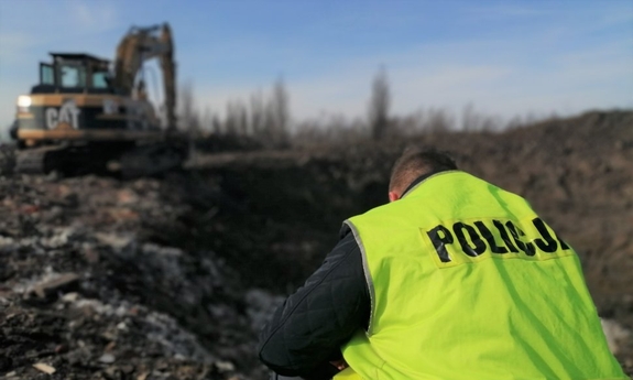 policjant podczas zabezpieczenia miejsce nielegalnego składowania odpadów