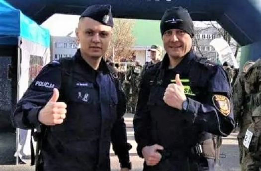 Policjant na mecie biegu z innym zawodnikiem