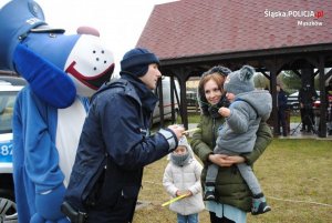 Policjant z maskotką zabawiają dziecko