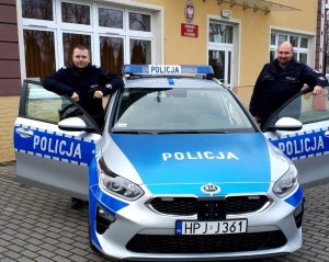 Policjanci przy radiowozie którzy uratowali desperata