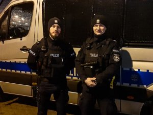 Policjanci na tle radiowozu