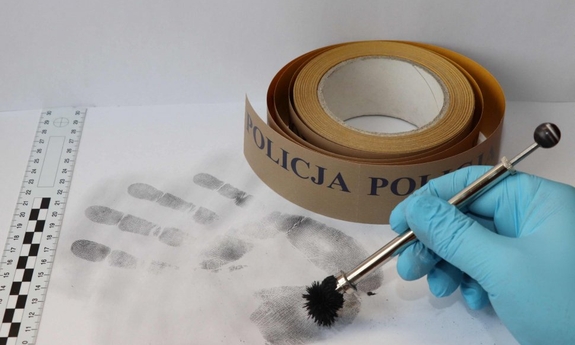 Policyjny technik zabezpiecza ślady linii papilarnych