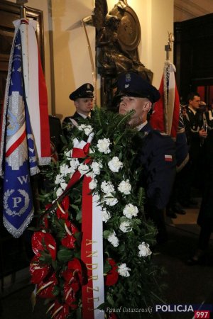 umundurowany policjant składa wieniec podczas mszy św. w intencji ofiar zbrodni katyńskiej