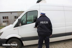 policjant stojący przy skradzionym mercedesie