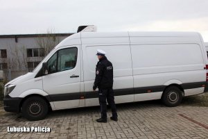 policjant stojący przy skradzionym mercedesie