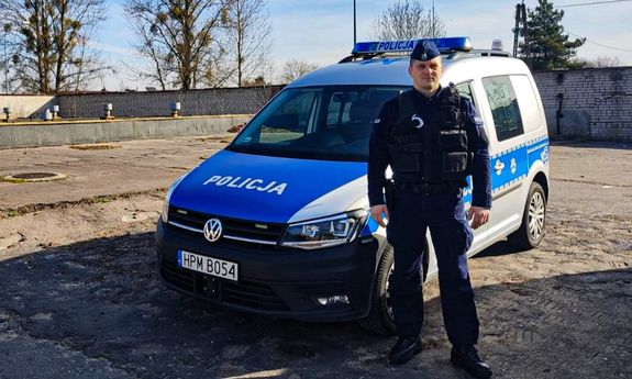 policjant stojący przy radiowozie