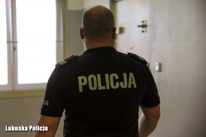 Policjant przed pomieszczeniem dla osób zatrzymanych