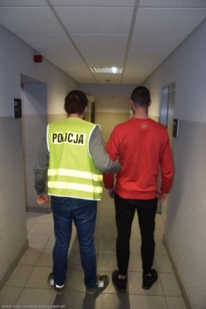 policjant prowadzi zatrzymanego