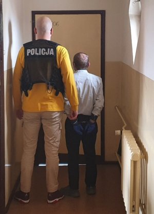 Zatrzymany mężczyzna obok policjant