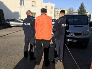 Zatrzymany mężczyzna w eskorcie dwóch policjantów