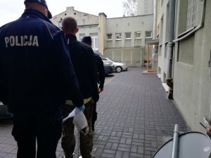 dwaj policjanci z zatrzymanym mężczyzną