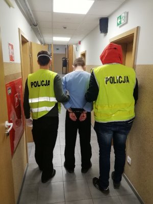 dwaj policjanci z zatrzymanym mężczyzną