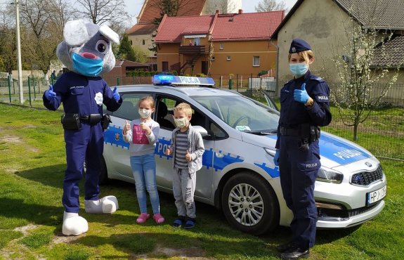 Policjanci rozdający maseczki dzieciom