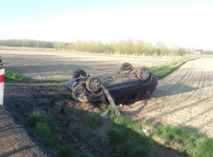 Samochód po dachowaniu leżący na dachu w polu