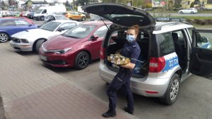 policjantka wypakowuje żywność z auta