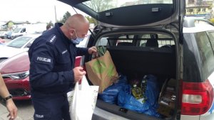 policjant wypakowuje żywność z auta