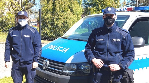 dwaj policjanci przed radiowozem