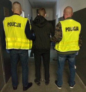 policjanci prowadzą zatrzymanego mężczyznę