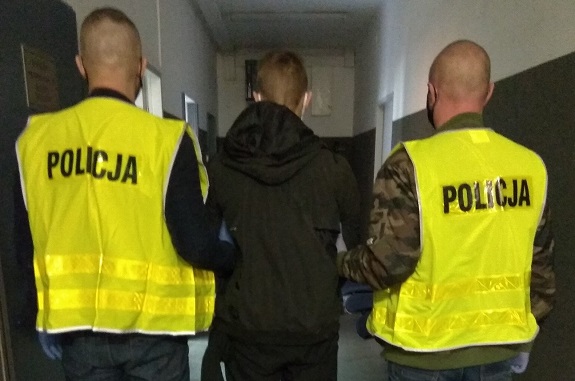 policjanci prowadzą zatrzymanego mężczyznę