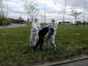 policjanci w specjalnych kombinezonach ochronnych podczas zatrzymania mężczyzny