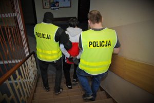 Zatrzymany mężczyzna prowadzony prze dwóch policjantów