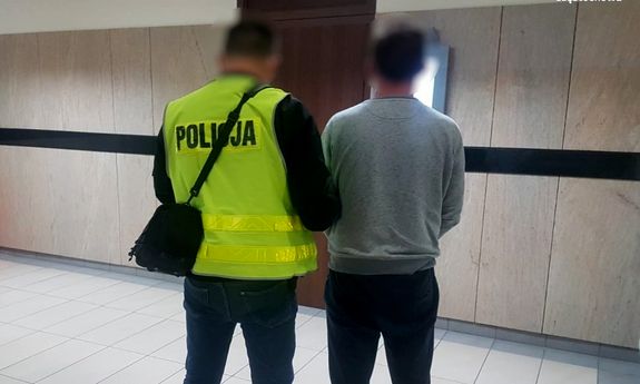 policjant prowadzi zatrzymanego mężczyznę