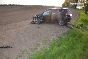 Zdjęcie z wypadku motocyklisty, który zderzył się z samochodem osobowym. Rozbite pojazdy na polu