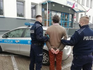 Policjanci prowadzą zatrzymanego