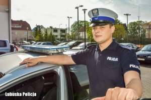 policjant stoi przy radiowozie