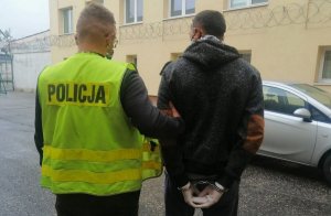 policjant prowadzi zatrzymanego mężczyznę