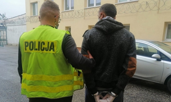 policjant prowadzi zatrzymanego mężczyznę