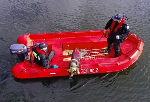 dwaj policjanci na łodzi i pies