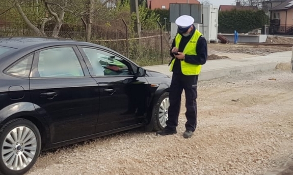 Policjant prowadzi czynności przy samochodzie