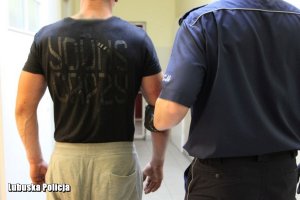 policjant prowadzi zatrzymanego mężczyznę