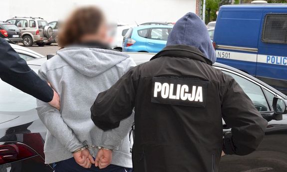 Policjanci prowadzą zatrzymanego