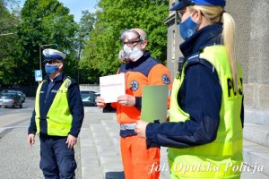 policjanci i ratownicy medyczni stoją obok siebie w ręce trzymając kartkę z napisem #murem za medykiem&quot;