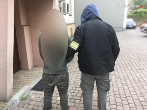 nieumundurowany policjant prowadzi zatrzymanego chwytem transportowym&quot;&gt;