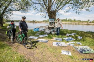 rowerzyści oglądają plenerową wystawę fotografii w Kuligowie nad Bugiem w ramach obchodów 100-lecia Policji Rzecznej I Komisariatu Rzecznego Policji w Warszawie