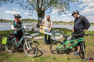 rowerzyści oglądają plenerową wystawę fotografii w Kuligowie nad Bugiem w ramach obchodów 100-lecia Policji Rzecznej I Komisariatu Rzecznego Policji w Warszawie