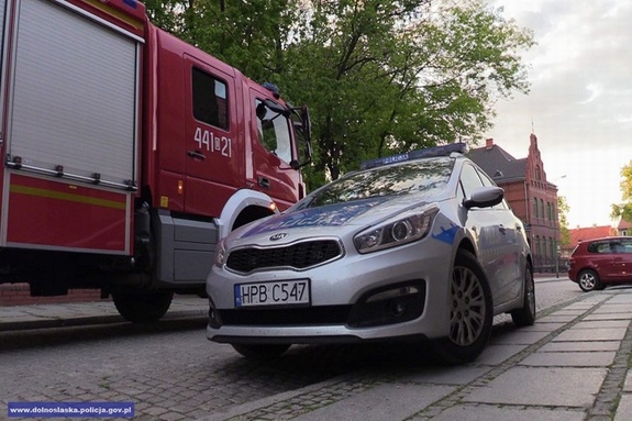 policyjny radiowóz stoi obok wozu strażackiego