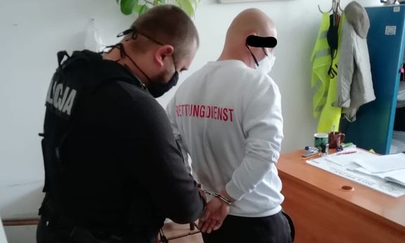 policjant z zatrzymanym mężczyzną