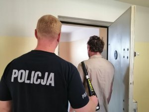 zatrzymany mężczyzna z policjantem w policyjnym areszcie