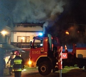 wóz straży pożarnej przed palącym się domem
